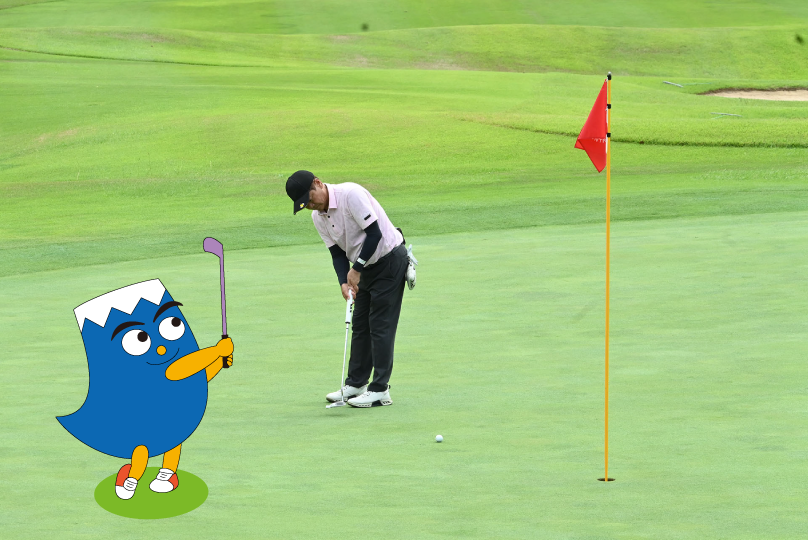 グリーン上でパットを打つ選手