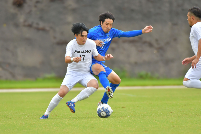 サッカーの試合でボールを競り合う選手