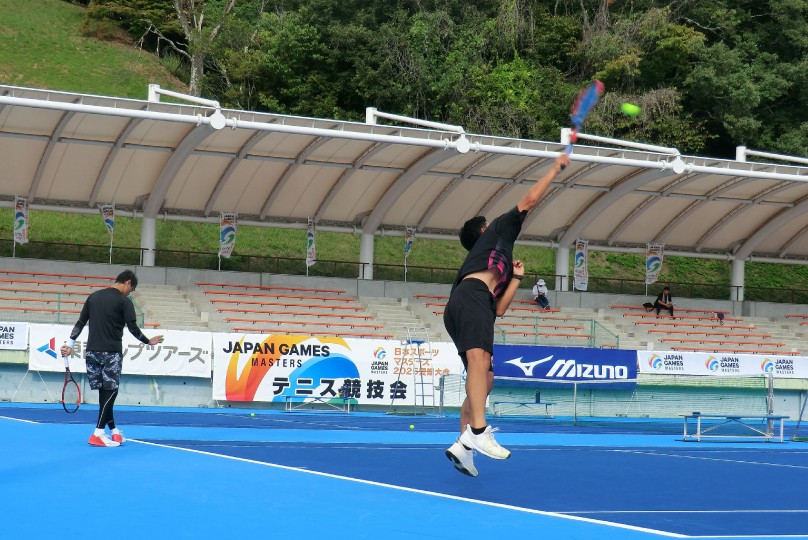 テニスの試合でサーブを打つ選手