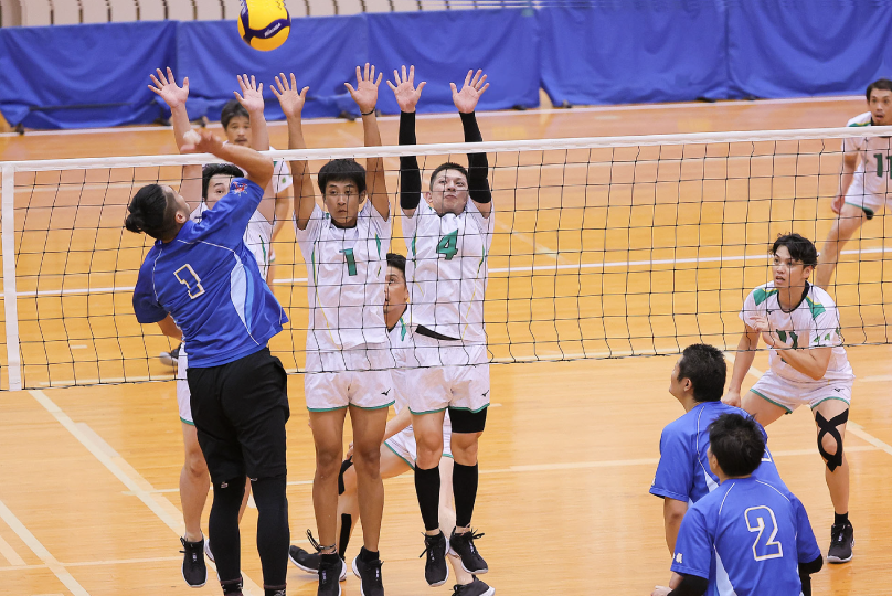 バレーボールの試合でスパイクを打つ男子選手