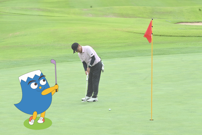 グリーン上でパットを打つ選手