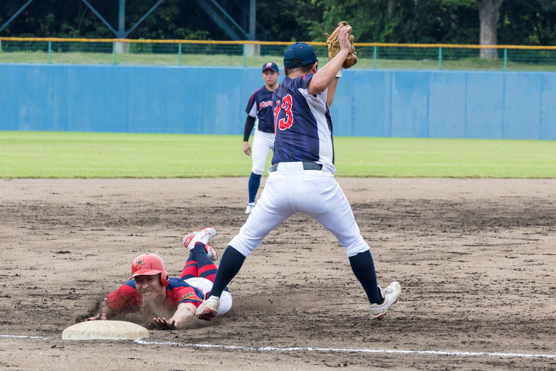 軟式野球の試合で走者が塁に滑り込む場面
