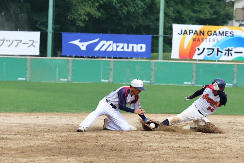 ソフトボールの試合で塁上のプレーを行う選手