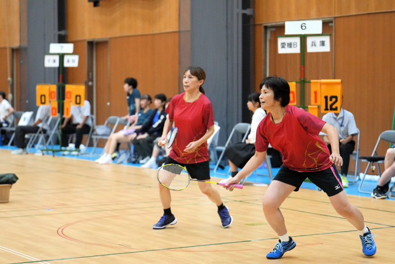 バドミントンの試合でシャトルを打ち返す選手